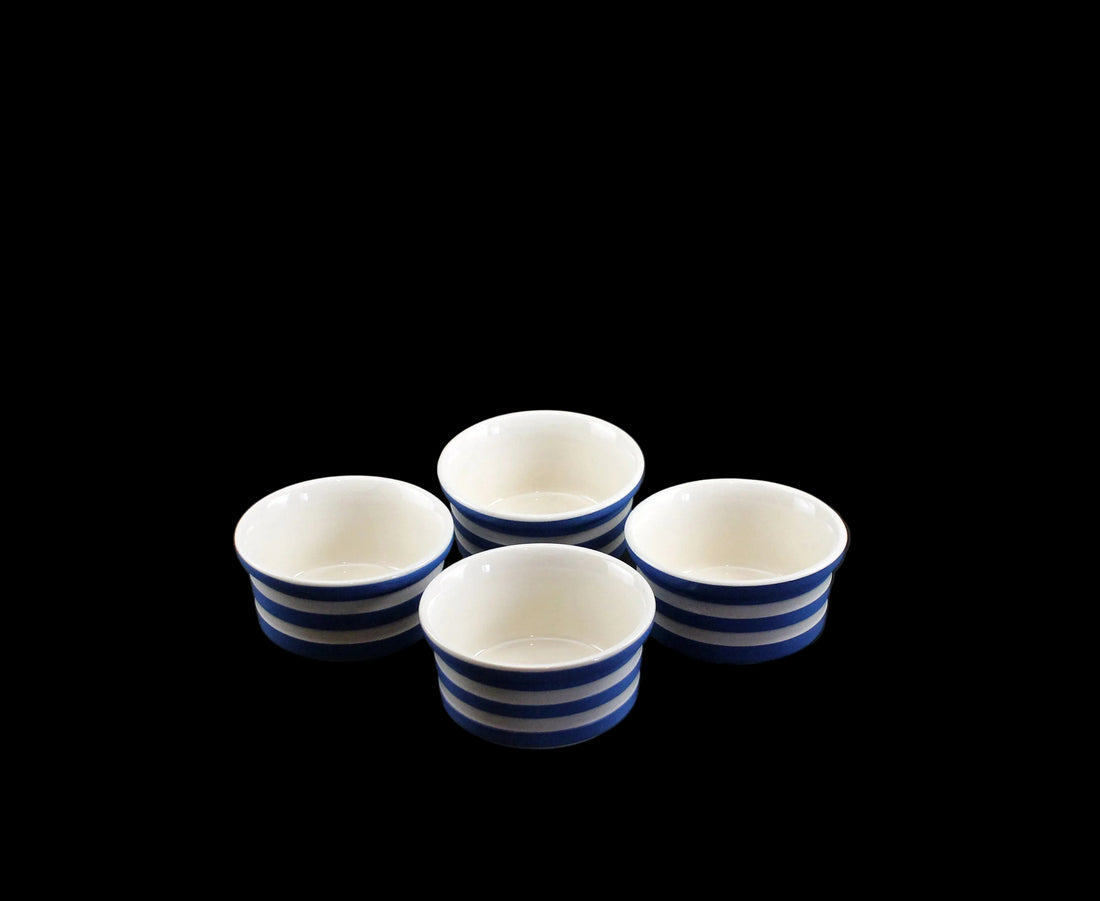 Four ceramic ramekins with blue stripes on a black background