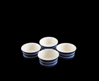 Four ceramic ramekins with blue stripes on a black background