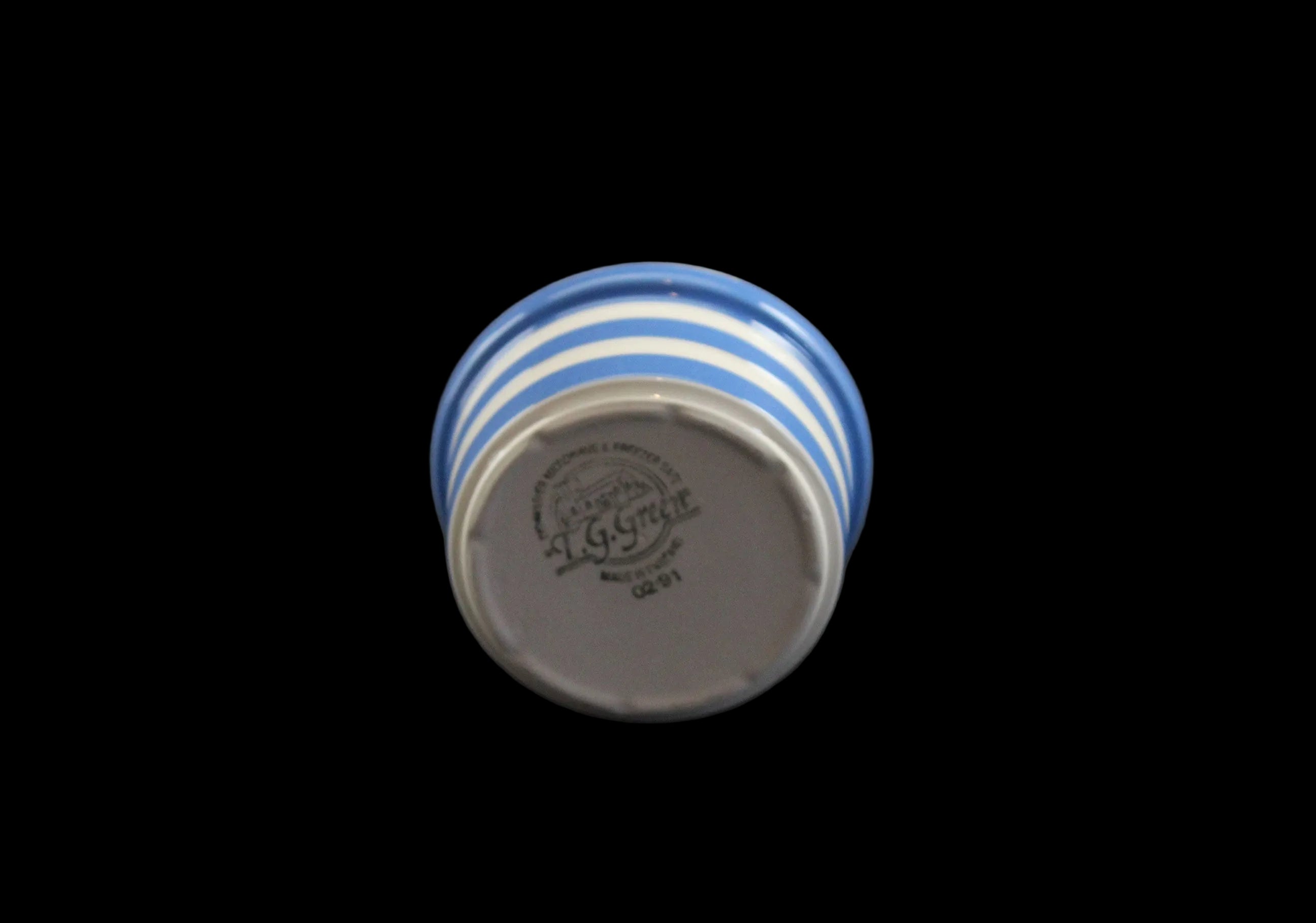 Ceramic bowl with blue and white stripes on a dark background
