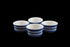Four ceramic ramekins with blue and white stripes on a dark background