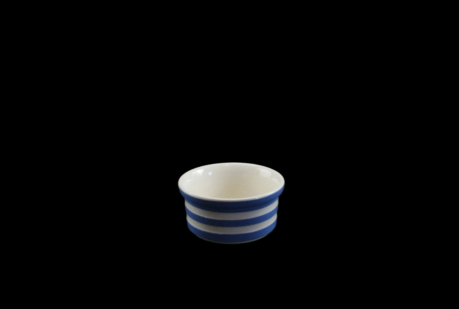 Small ceramic bowl with blue and white stripes on a black background