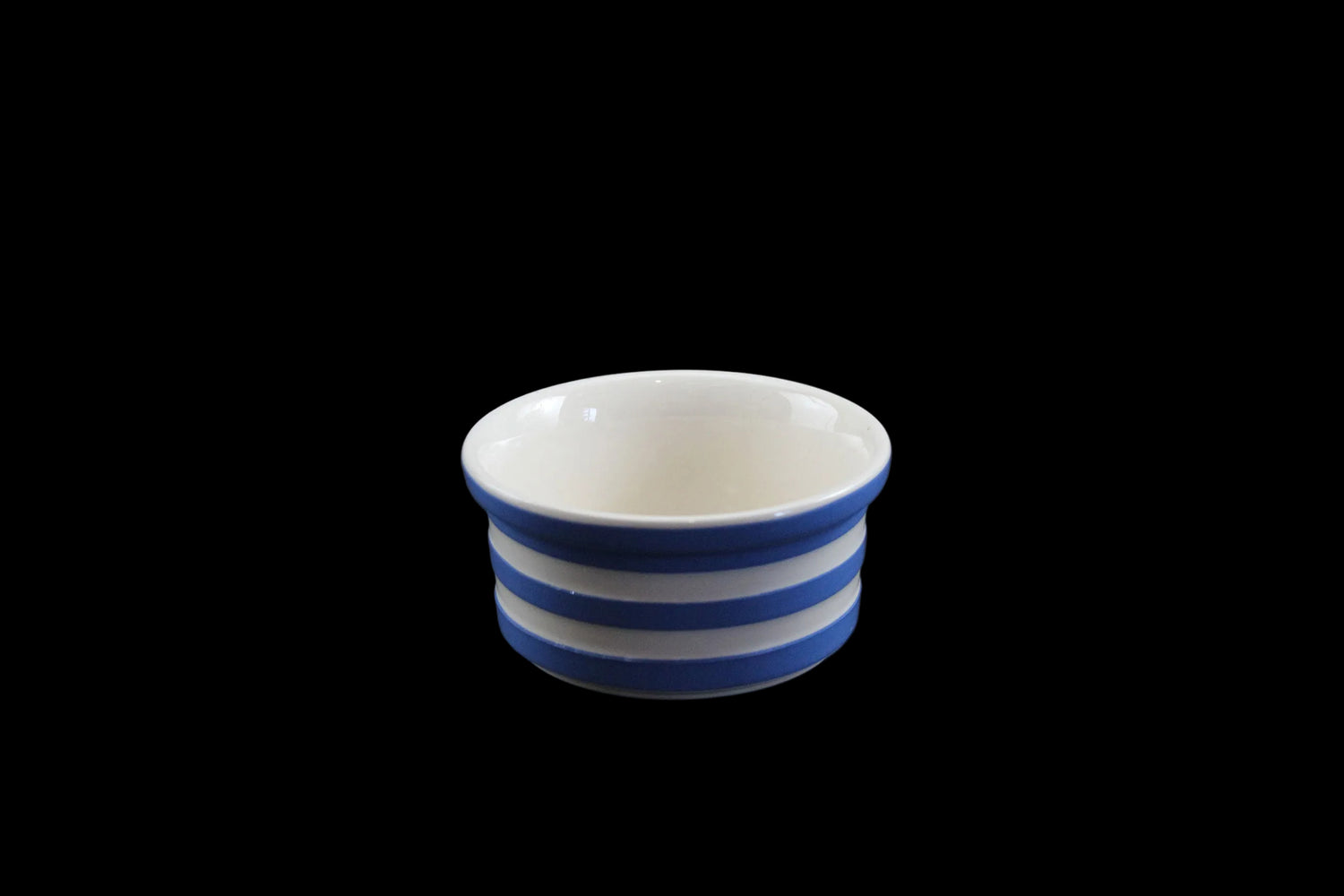 Ceramic bowl with blue and white stripes on a dark gray background