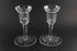 Two clear crystal candle holders on a black background