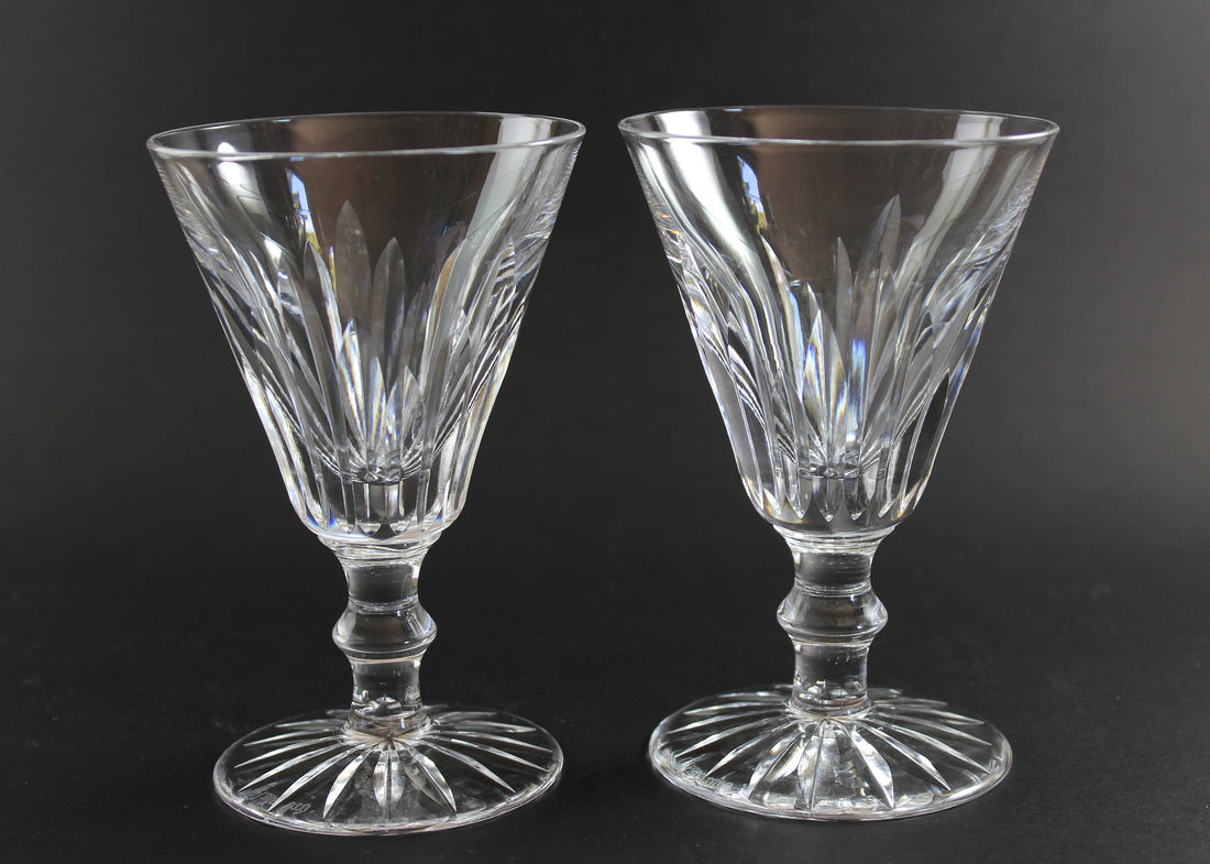 Two crystal glasses with intricate designs on a black background