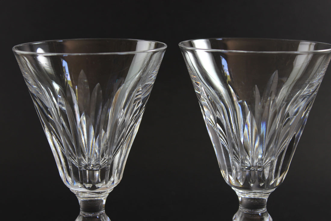 Two crystal glasses with intricate designs on a black background