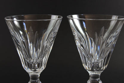 Two crystal glasses with intricate designs on a black background