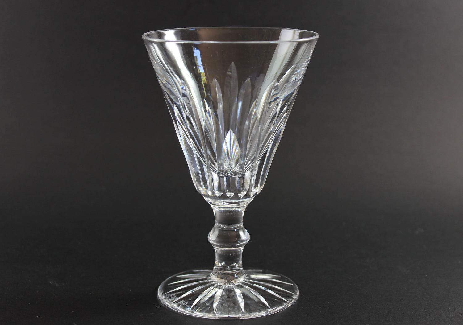 Cut crystal  goblet with intricate designs on a black background