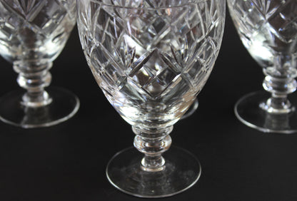 Close-up of crystal glasses with intricate cut patterns on a black background