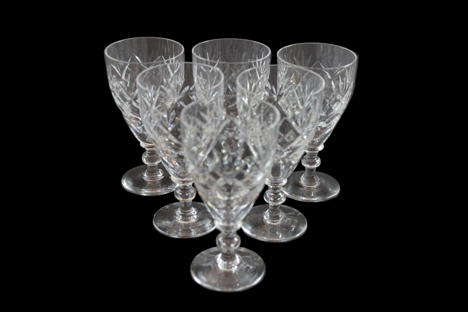 Set of six crystal sherry or port glasses on a dark background